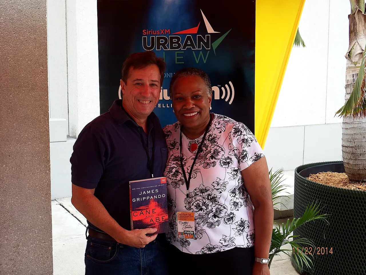 Maggie Linton with author James Grippando holding his novel Cane and Abe